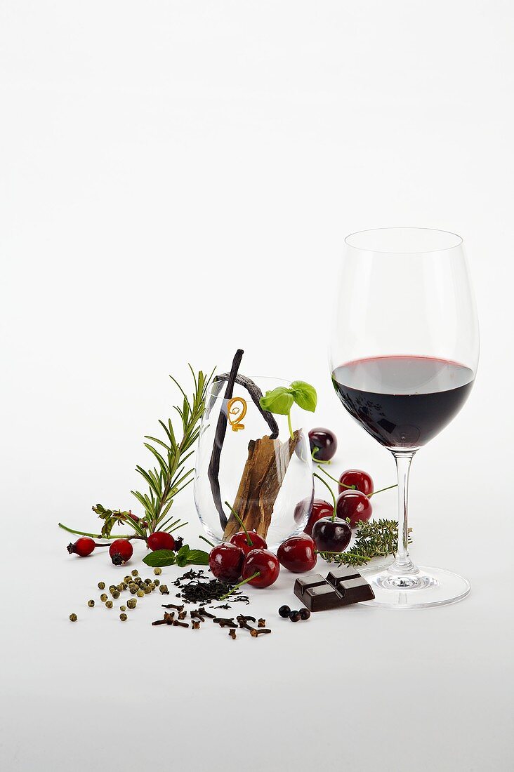 Rotweinglas und verschiedene aromatische Zutaten
