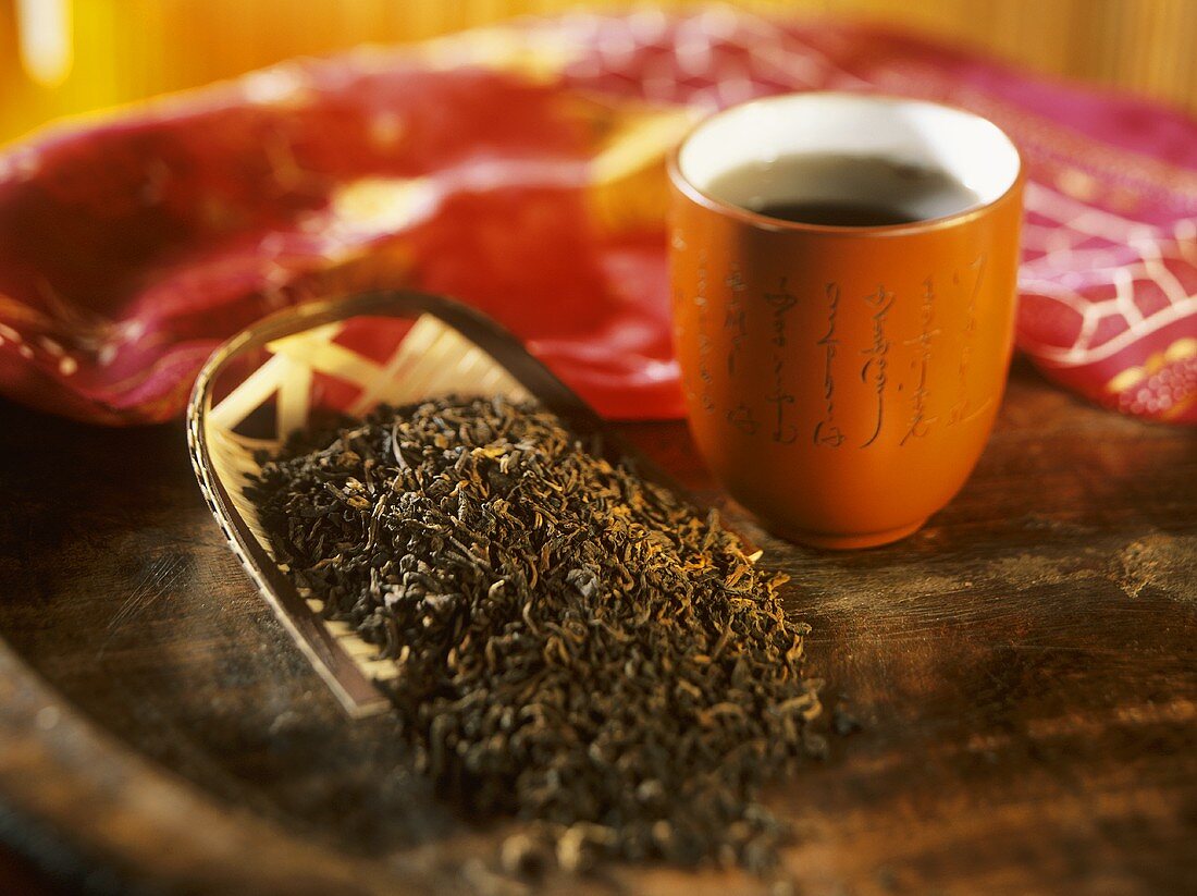 Pu-Erh-Tee: Teeblätter und Tee in Schälchen