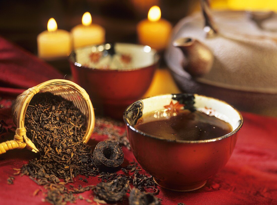 Pu-Erh-Tee in Teeschale, lose Teeblätter & gepresster Tee