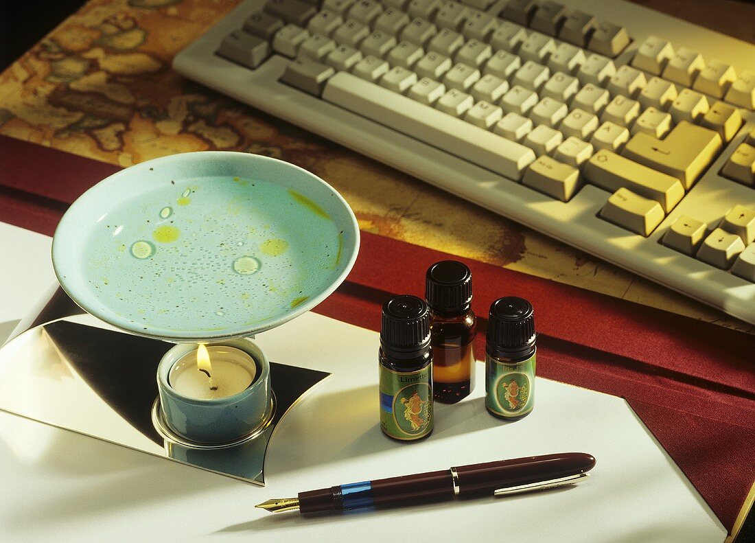 Aroma lamp and aromatic oils, computer keyboard in background