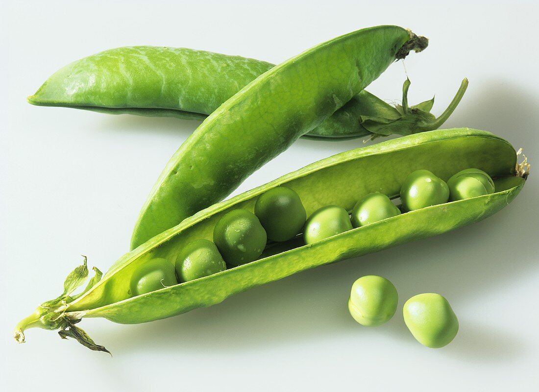 Three pea pods against a white background