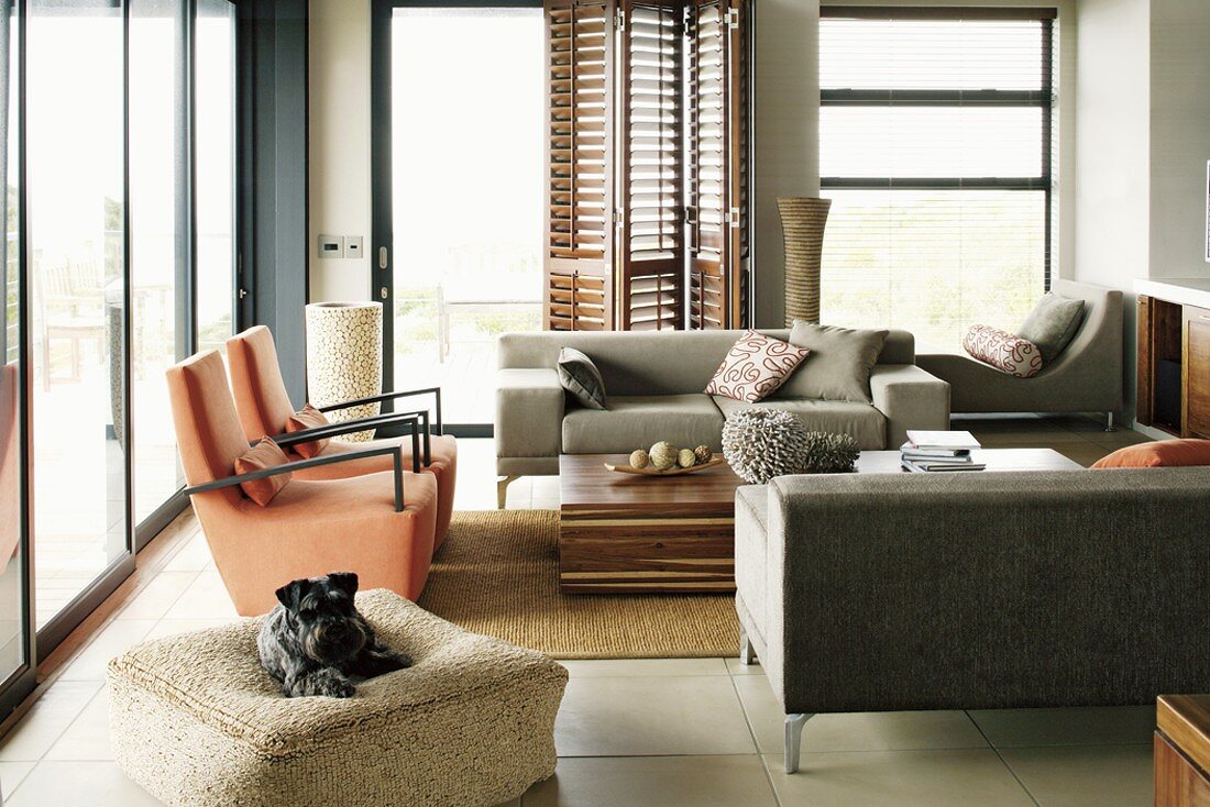 Zeitgenössisch eingerichtetes Wohnzimmer mit modernen Sofas und Sesseln sowie minimalistischem Couchtisch
