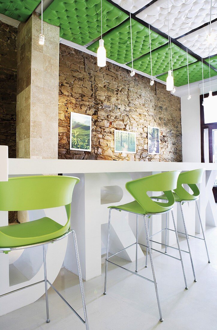 Zeitgenössischer Barthresen mit drei Stühlen in einem Raum mit Natursteinwand und gepolsterten Deckenpaneelen
