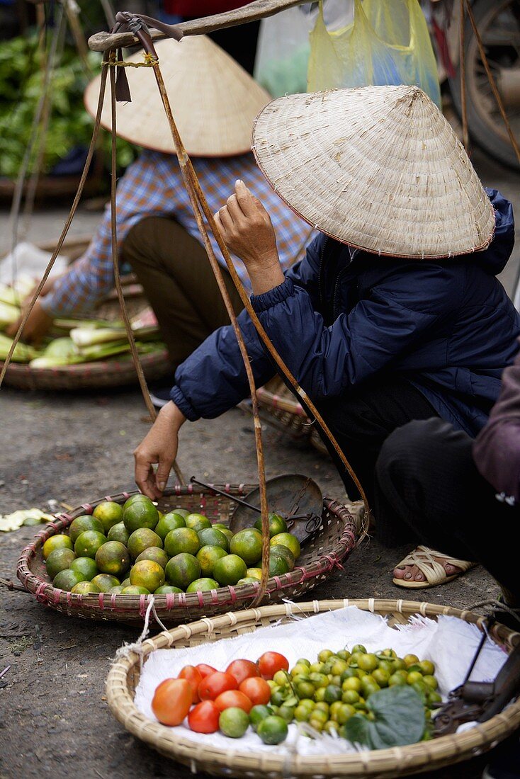 Vietnamesinnen verkaufen Obst, Gemüse auf einem Strassenmarkt