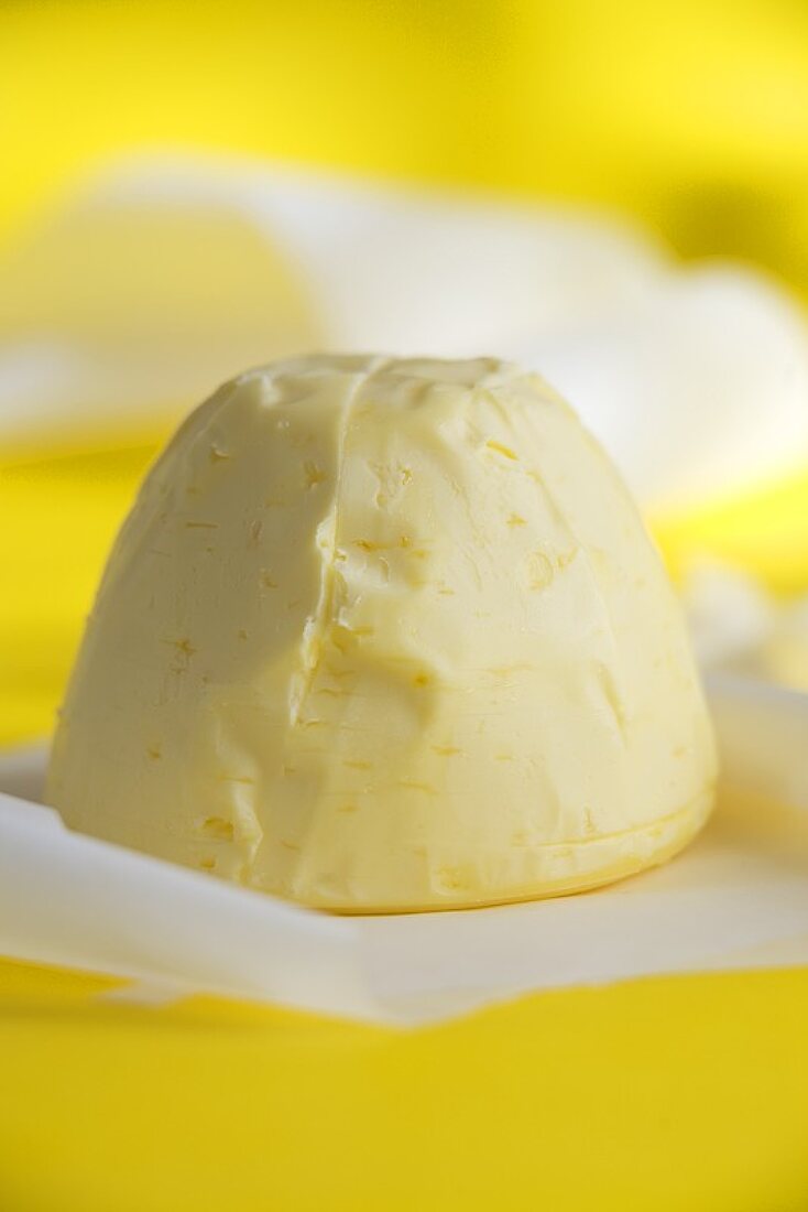 Piece of butter against yellow background