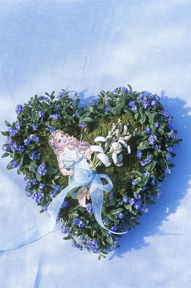 Forget-me-nots forming a heart, cut-out girl in the centre