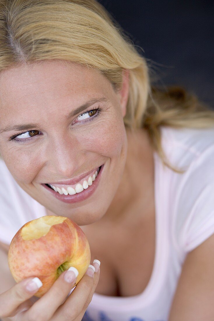 Frau isst einen Apfel