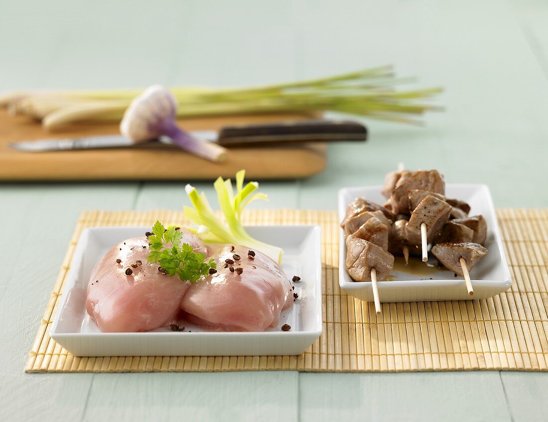 Still life with chicken breasts and Asian meat skewers