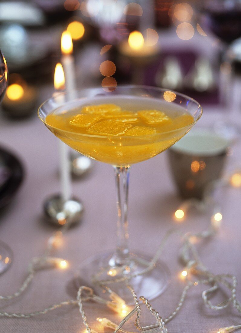 Sekt-Pfirsich-Cocktail mit Orangensaft-Eiswürfeln