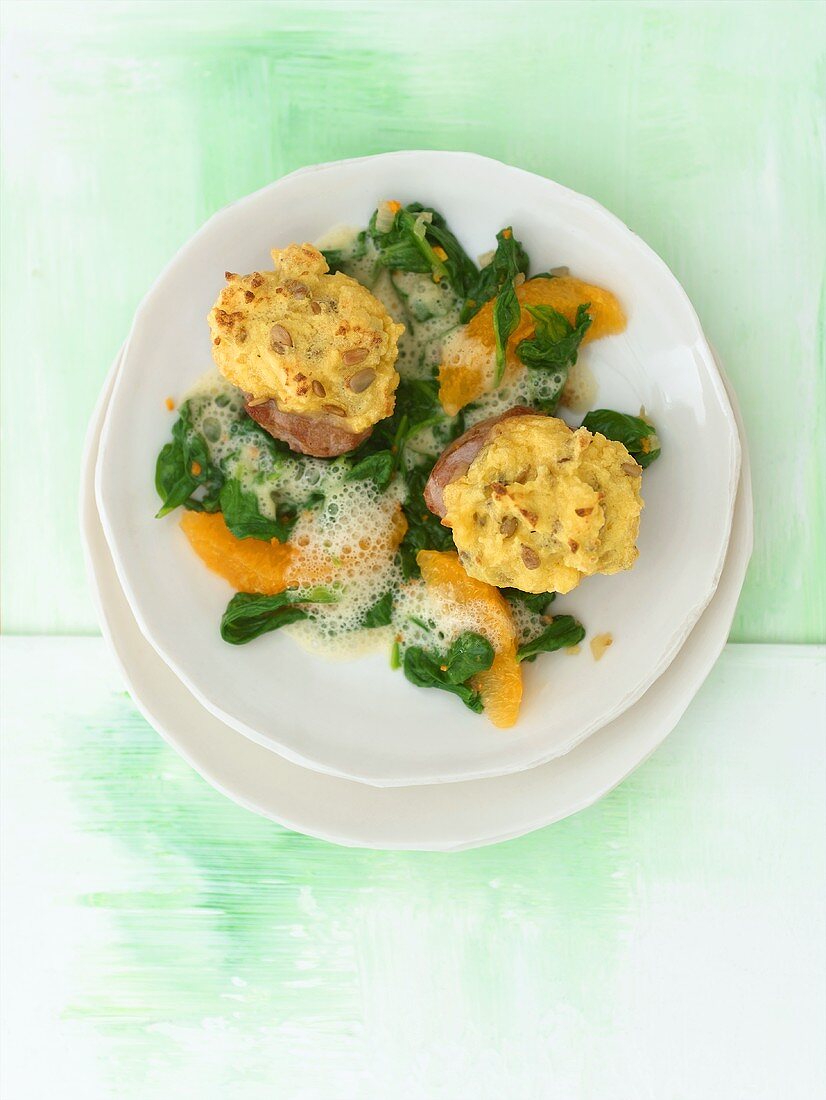 Baked pork fillet with orange segments on spinach