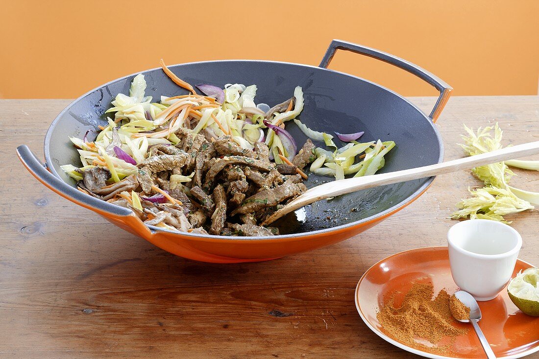 Stir-fried vegetables with strips of beef in wok