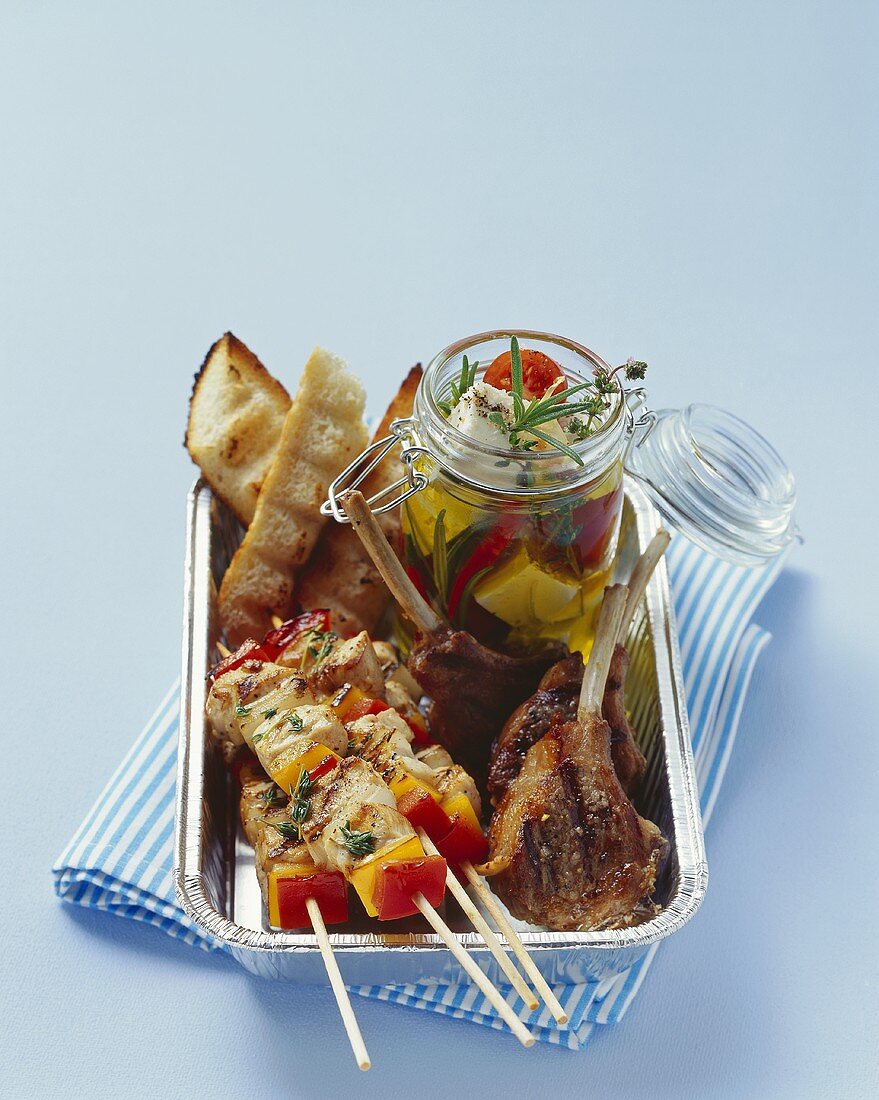 Kebabs, lamb chops and pickled cheese in aluminium dish