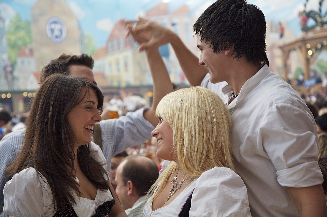 Cheerful young people in traditional dress at Bavarian fair