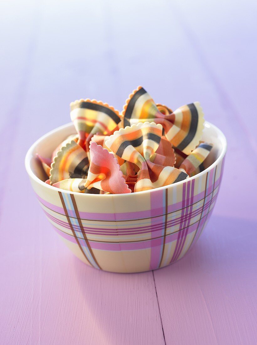 Multicoloured bow-tie pasta (farfalle) in a small bowl