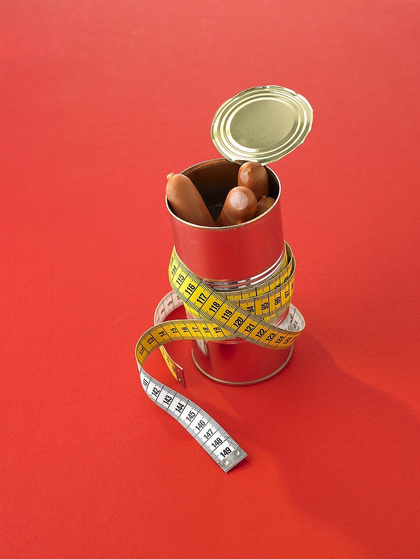 Frankfurters in a tin with a tape measure wrapped around it