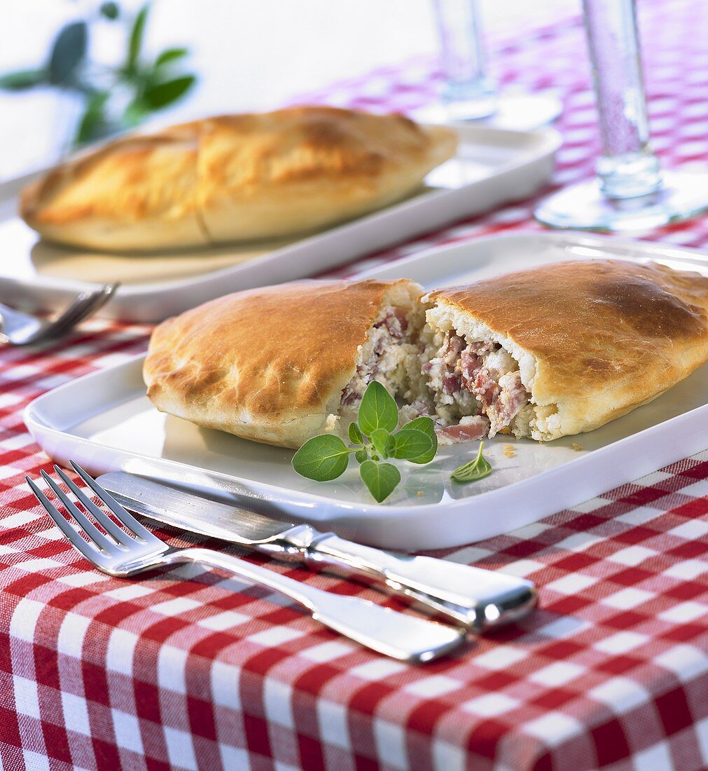 Two halved calzones with ricotta and ham filling