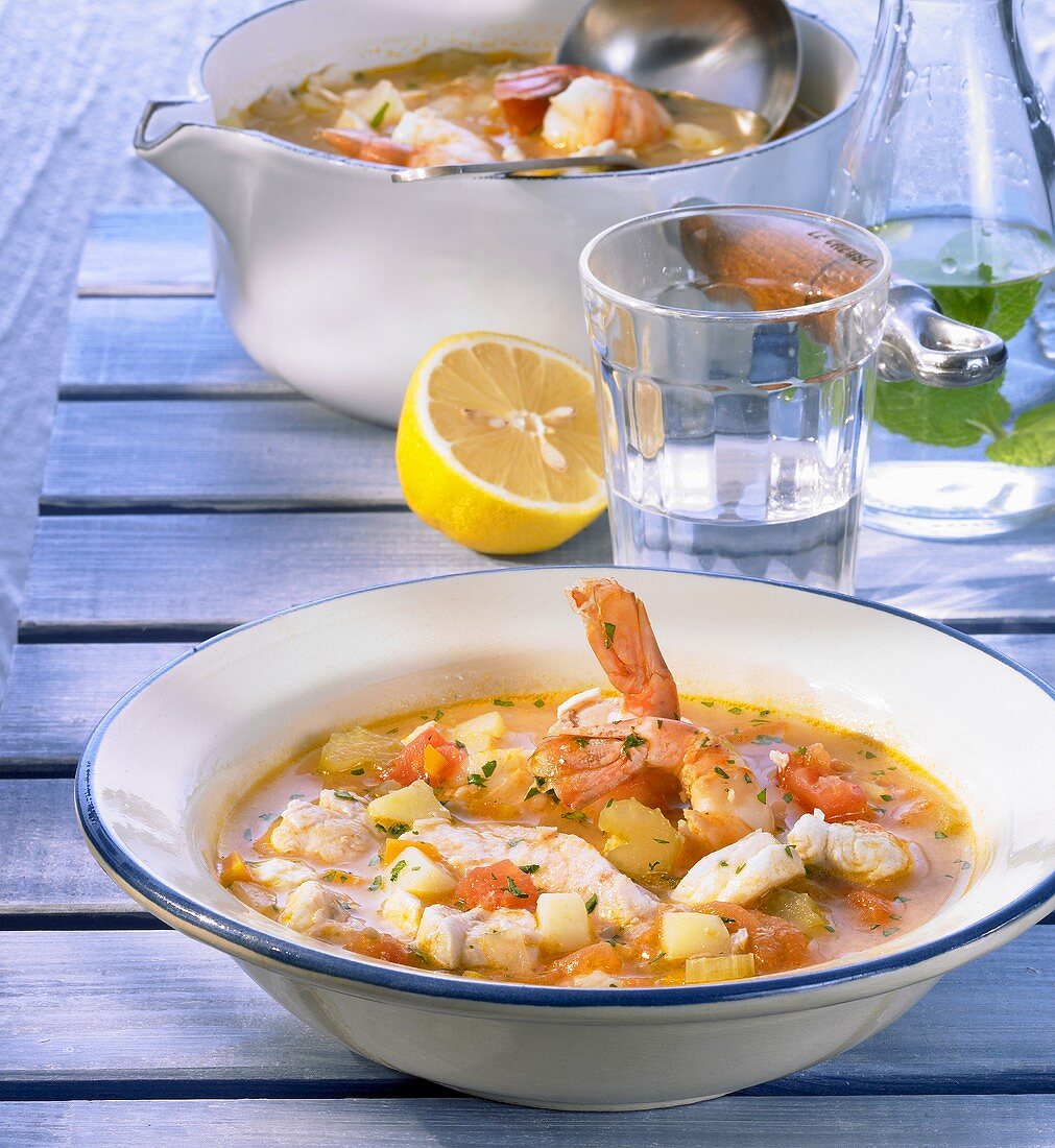 Ein Teller und eine Schüssel mit griechischer Fischsuppe