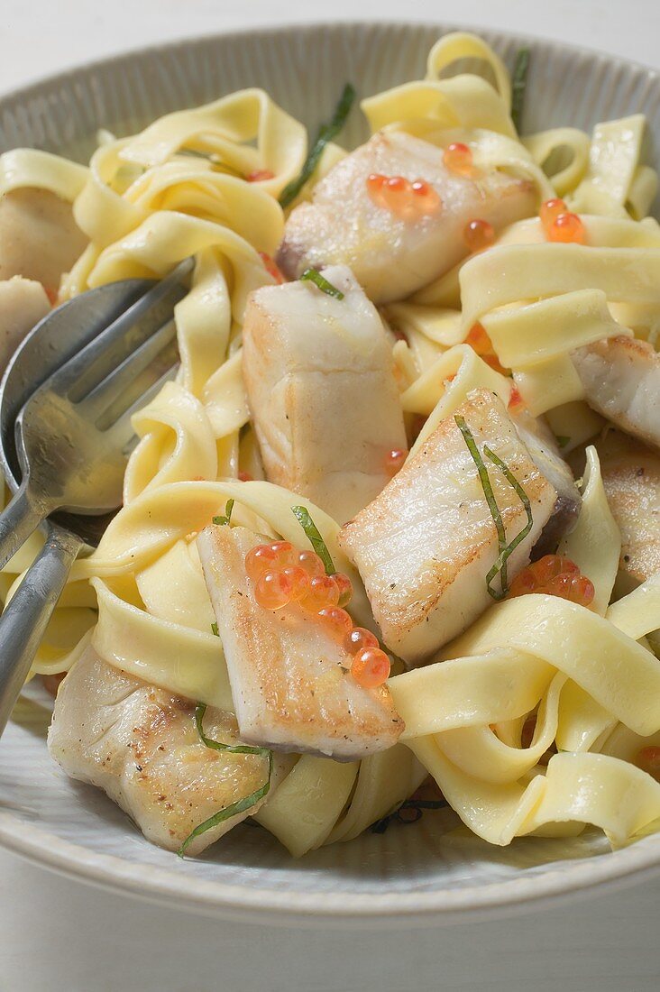 Ribbon pasta with pieces of tilapia fillet in lemon sauce