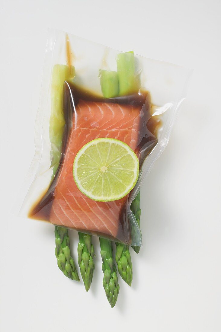 Vacuum-packed, marinated salmon fillet on asparagus
