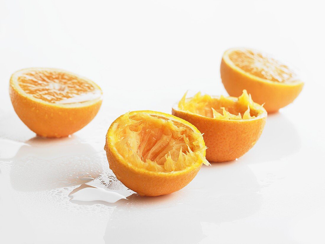 Orangenhälften, zwei davon ausgepresst