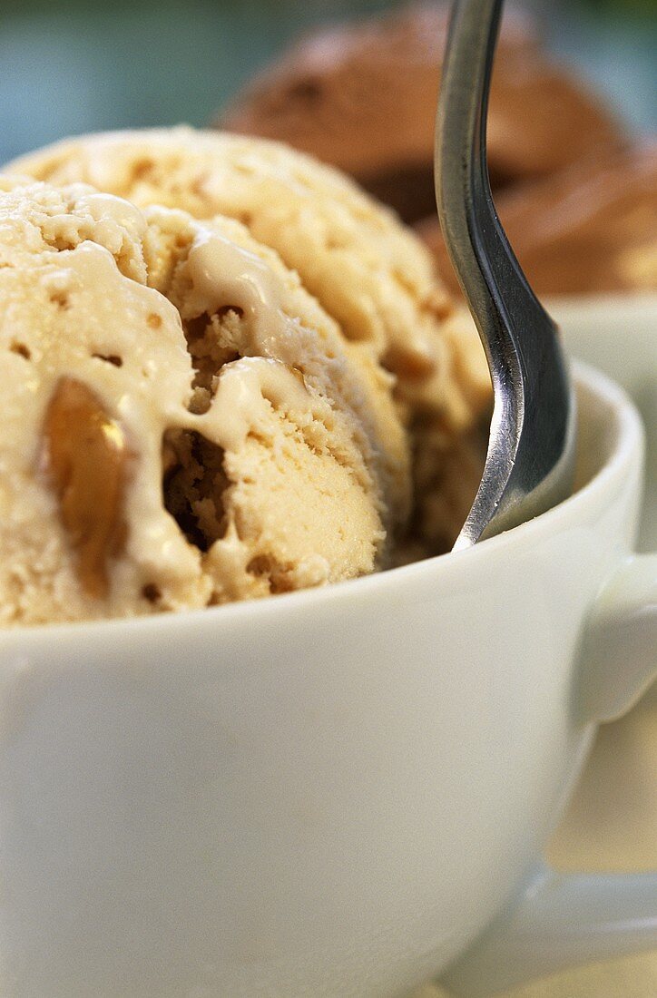 Caramel ice cream in cup with spoon