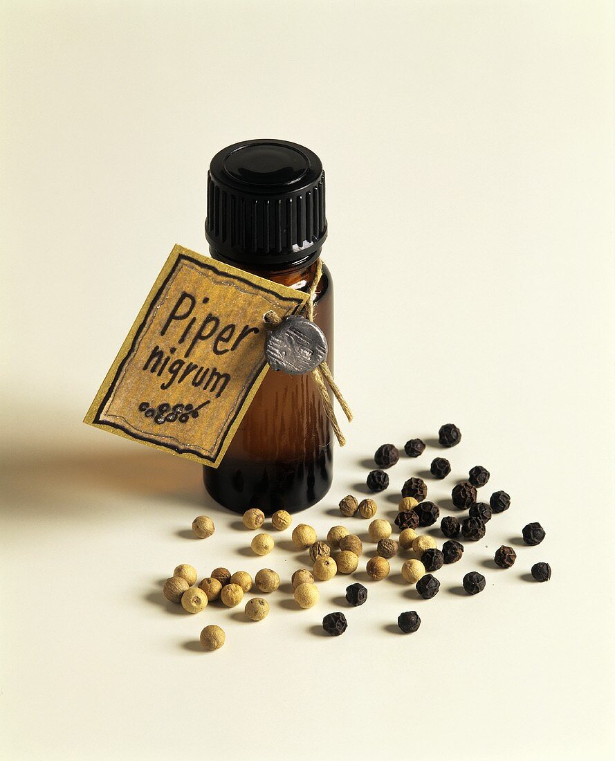 A small bottle of pepper oil and peppercorns