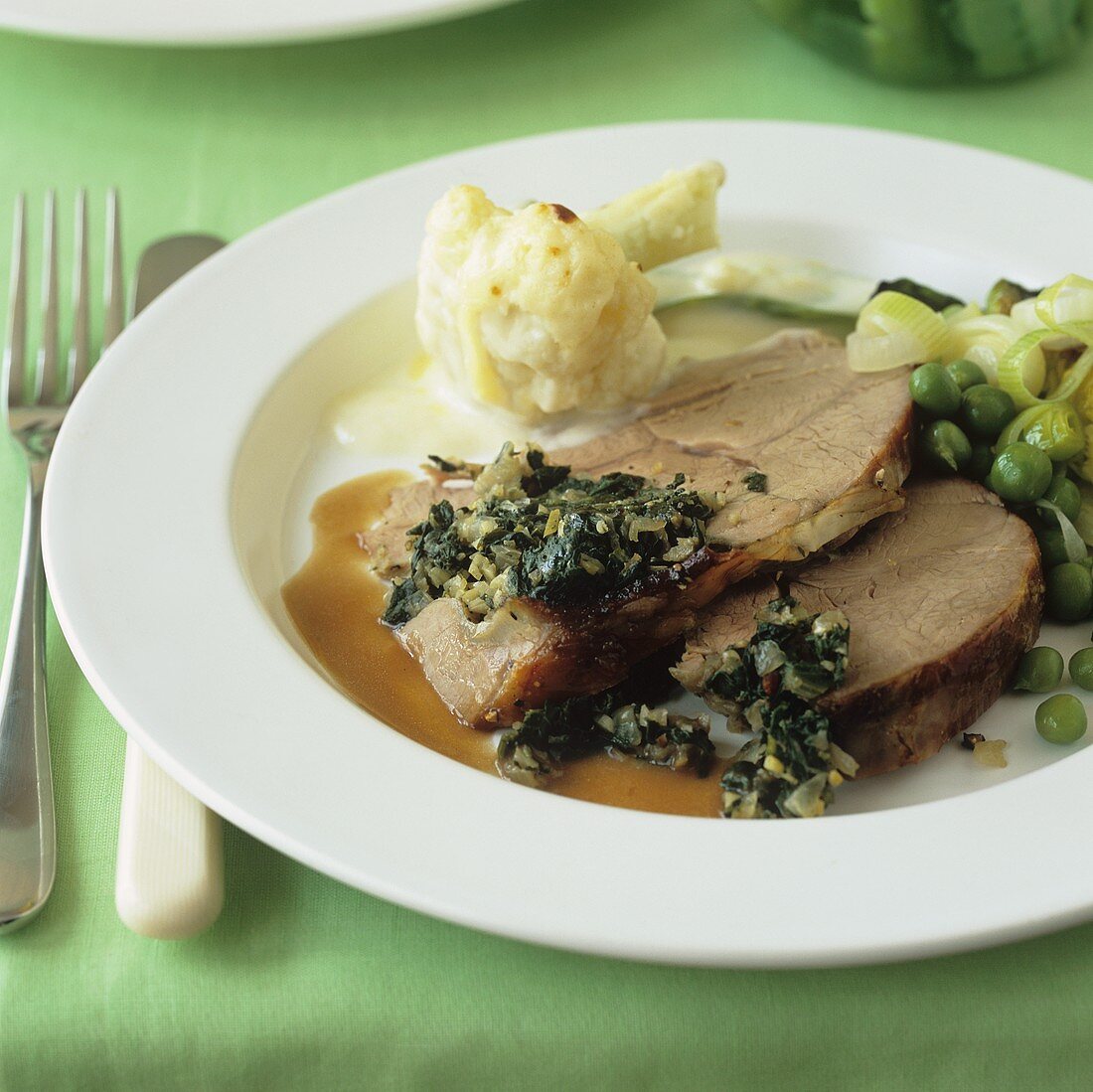 Roast lamb with spinach stuffing, cauliflower and peas