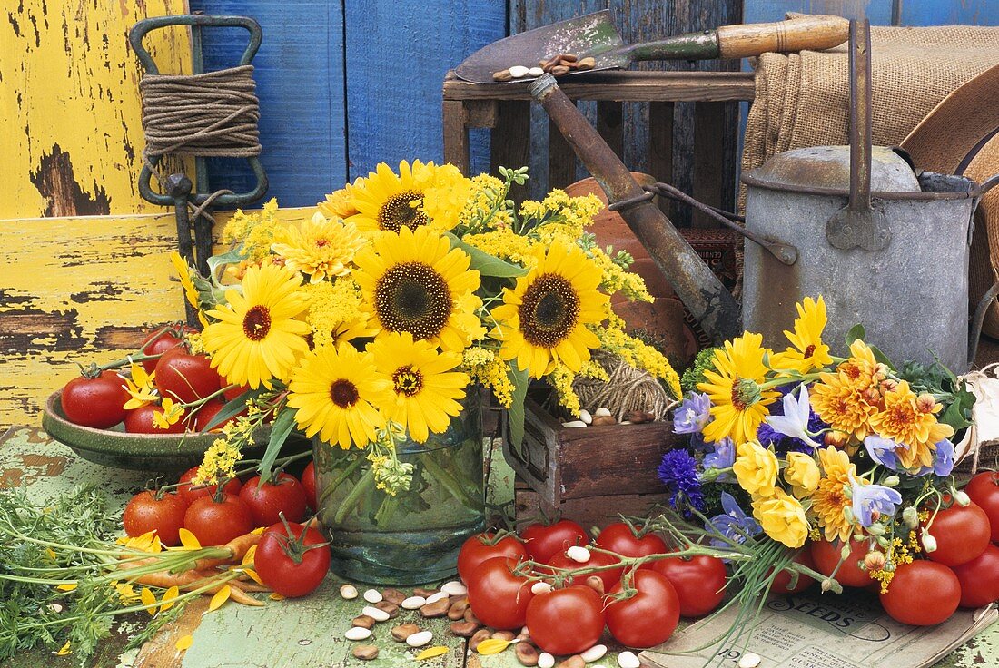 Vase and bunch of flowers and tomatoes out of doors