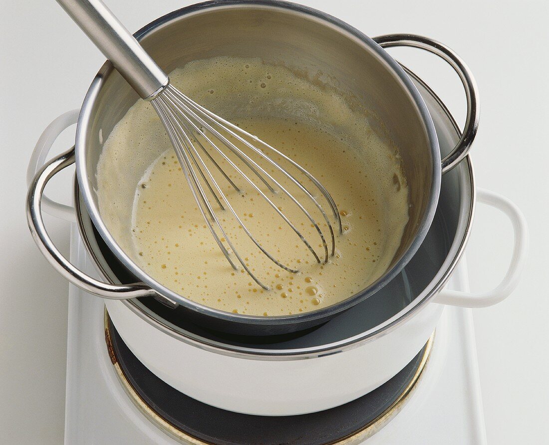 Stirring egg and milk over a bain-marie