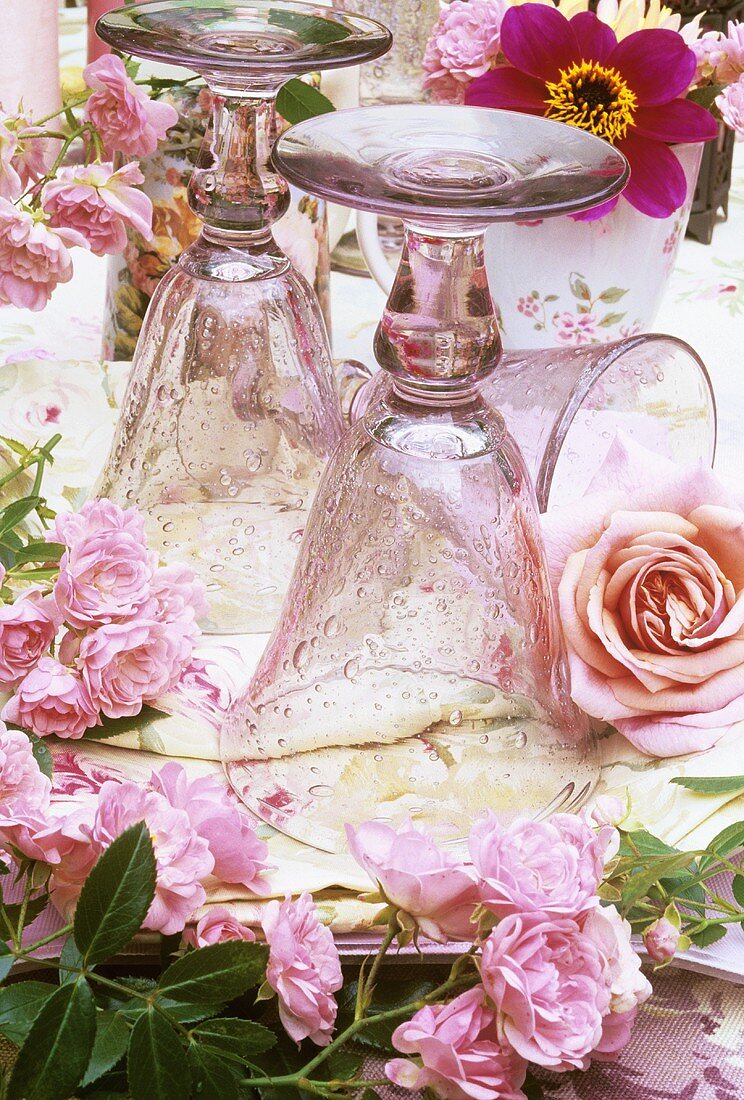 Pink glasses and roses on laid table