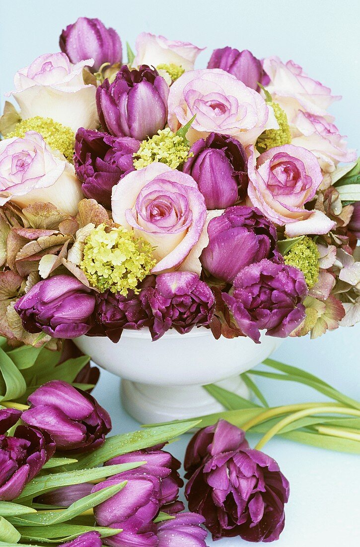 Arrangement of pink roses and purple tulips