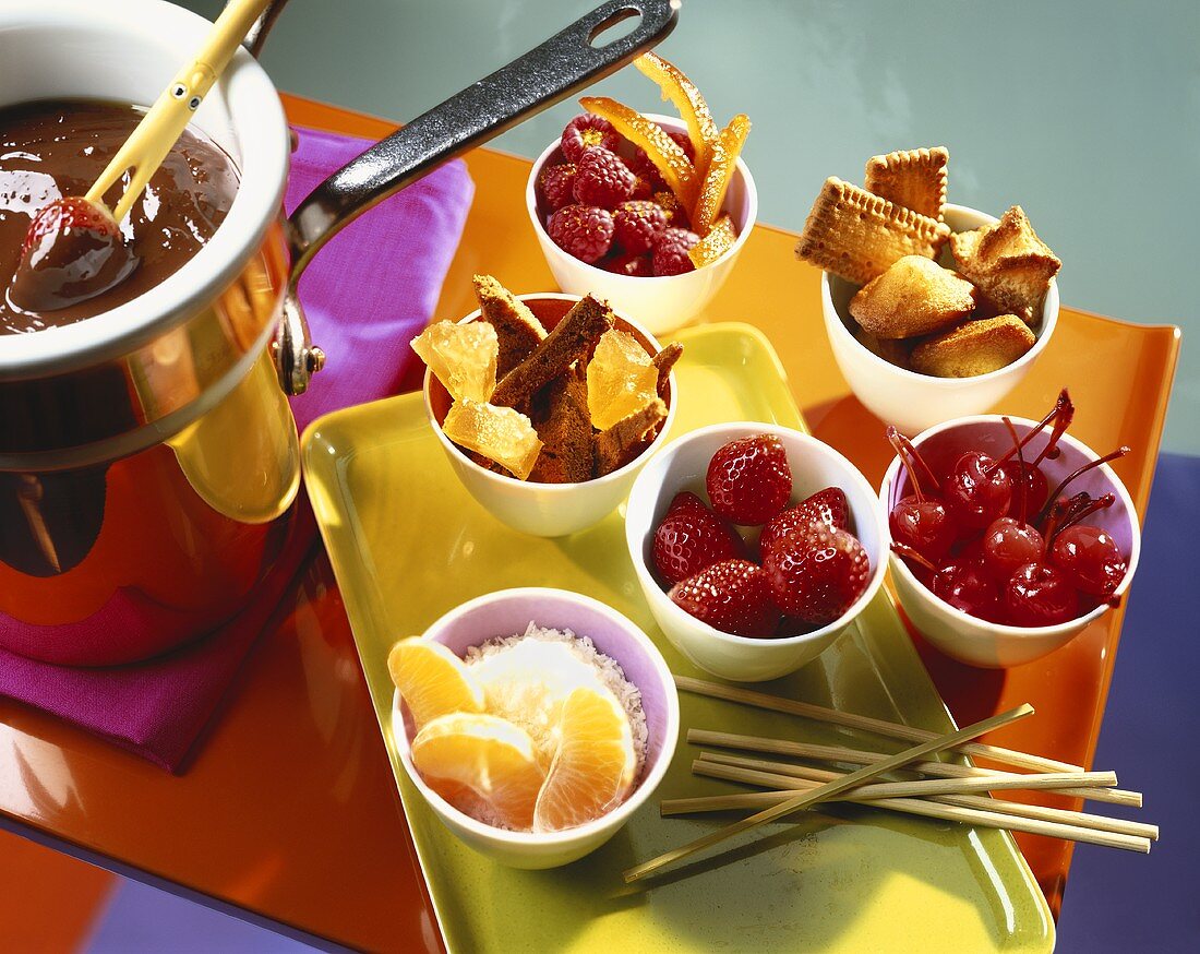 Chocolate fondue with assorted fruit and pieces of cake