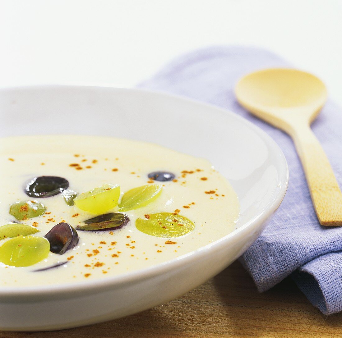 Vanilla soup with green and black grapes