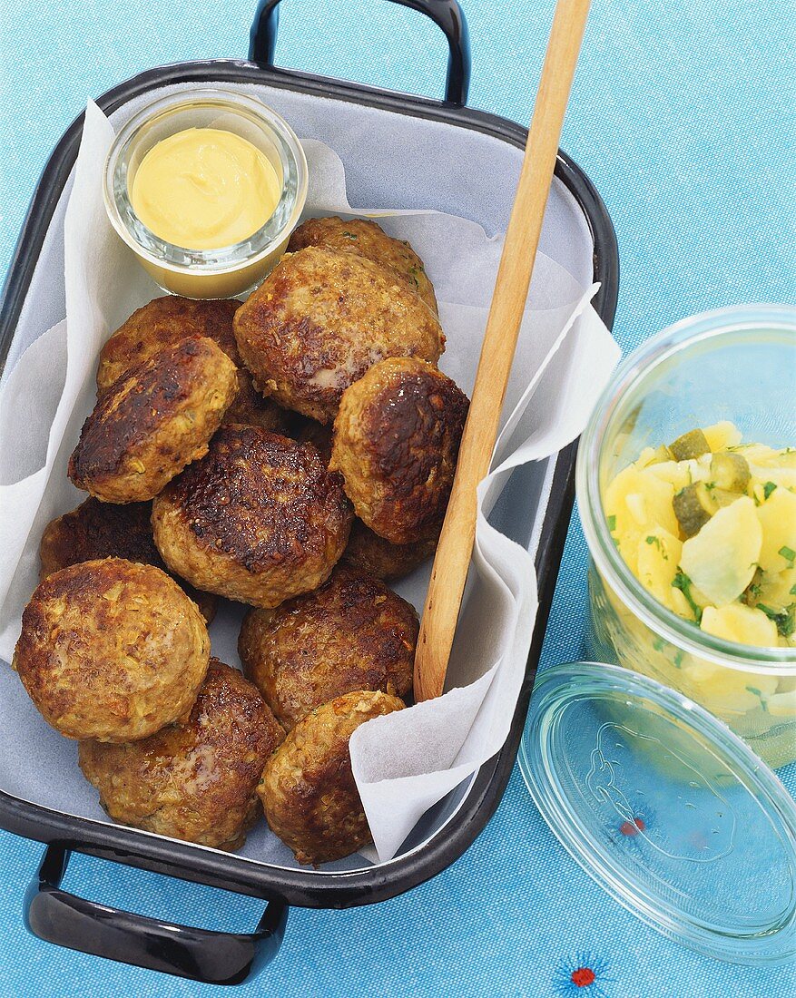 Meat patties with mustard and potato salad