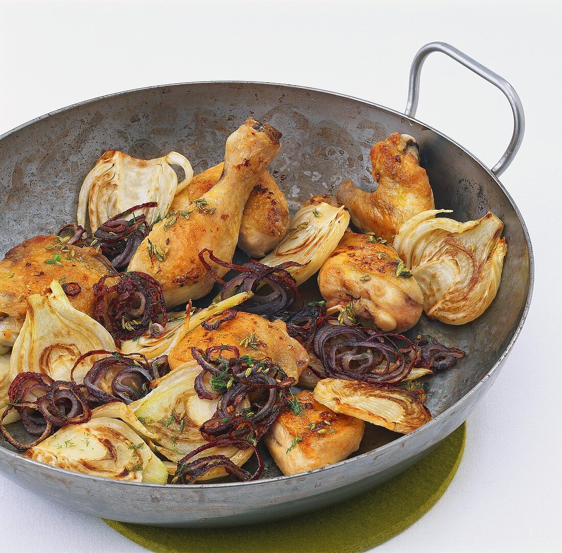 Chicken pieces on fennel and red onions