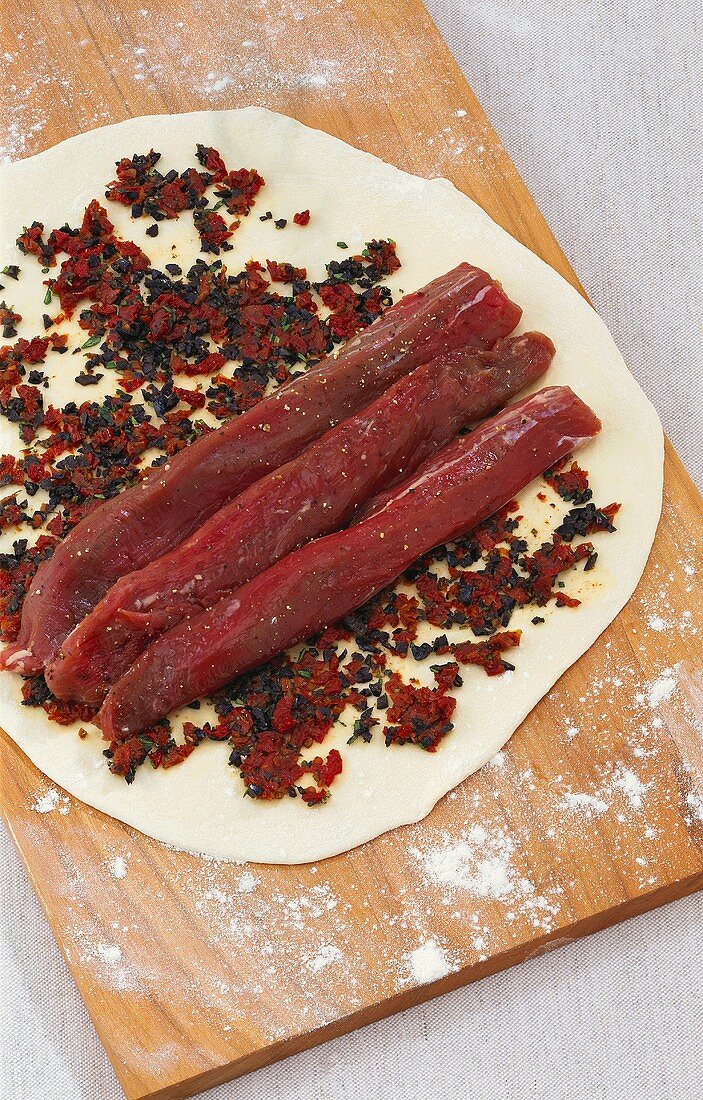 Preparing fillet of lamb in pizza dough