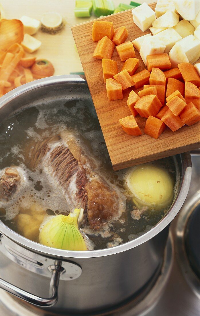 Preparing Tafelspitz (boiled beef): meat & vegetables in a pan