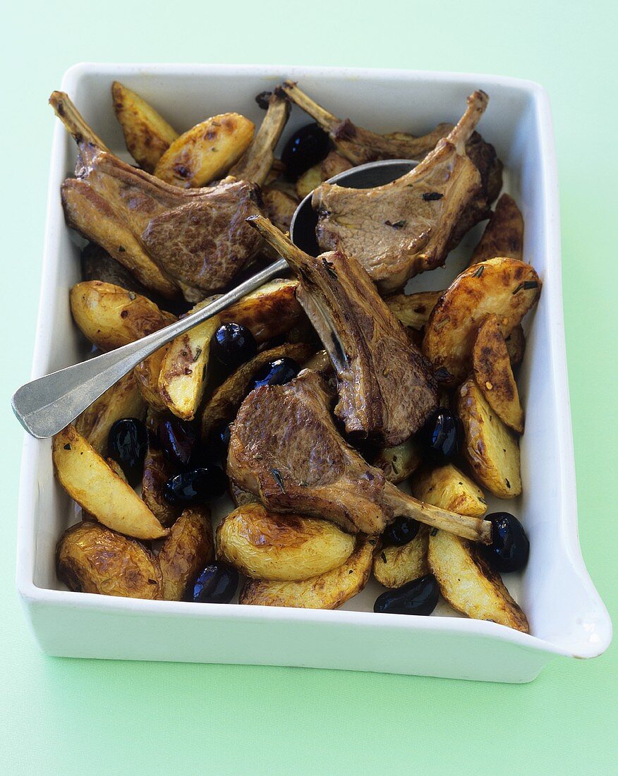 Lamb chops with olives and potatoes in a baking dish