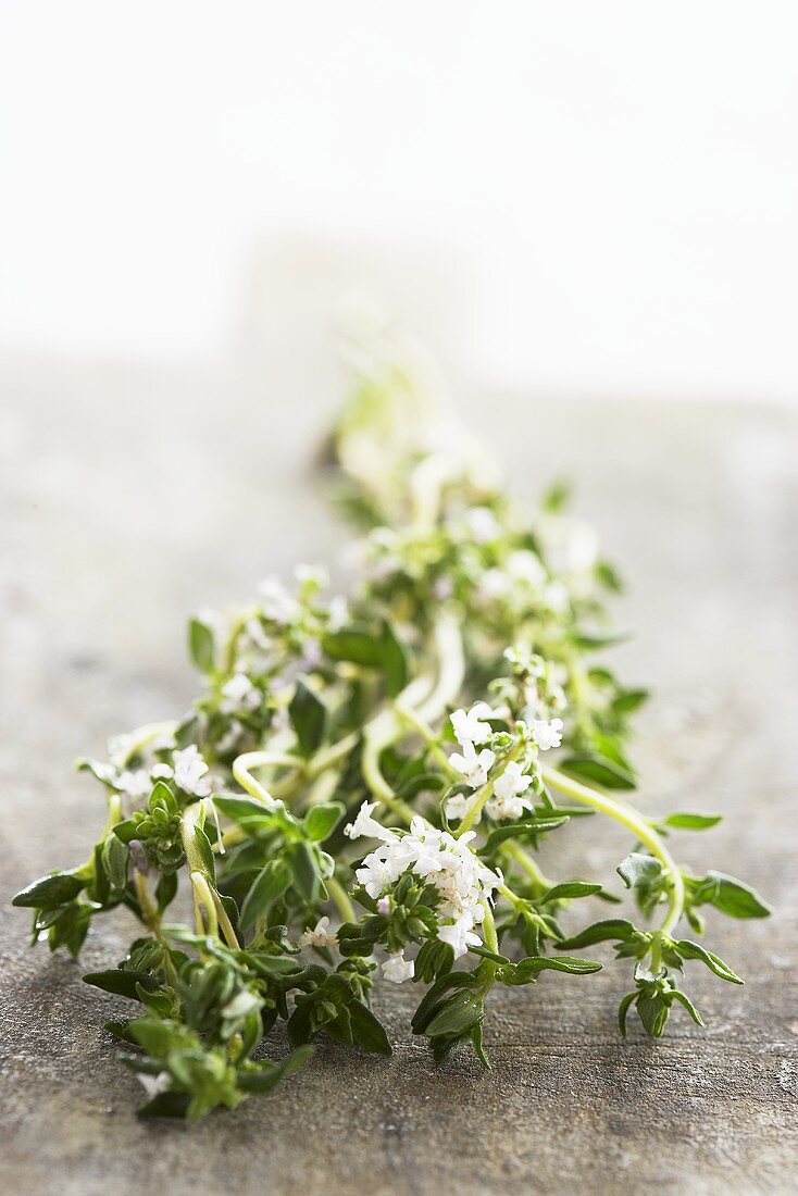 Thymian mit Blüten auf Holzbrett