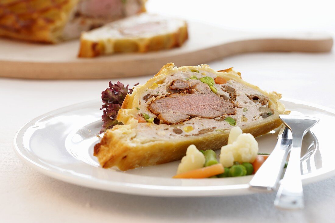 Pork fillet wrapped in puff pastry with vegetables