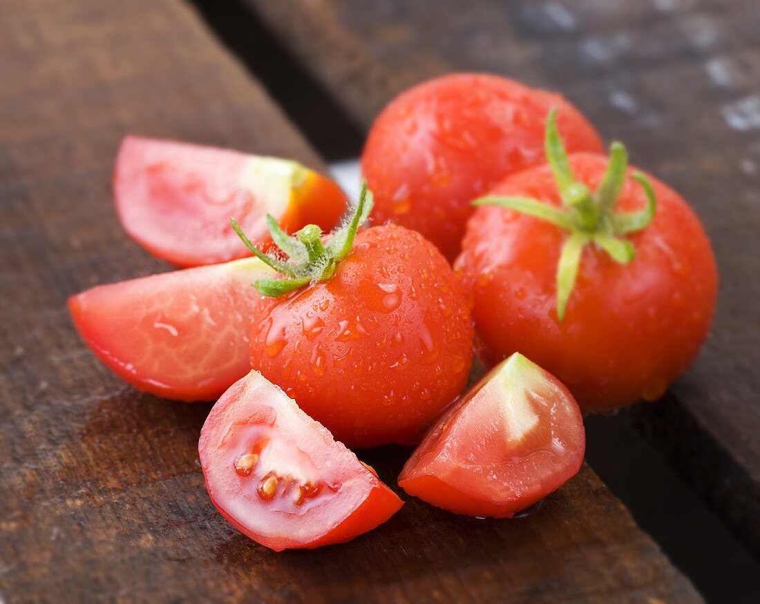 Tomaten, ganz und geschnitten auf Holzkiste