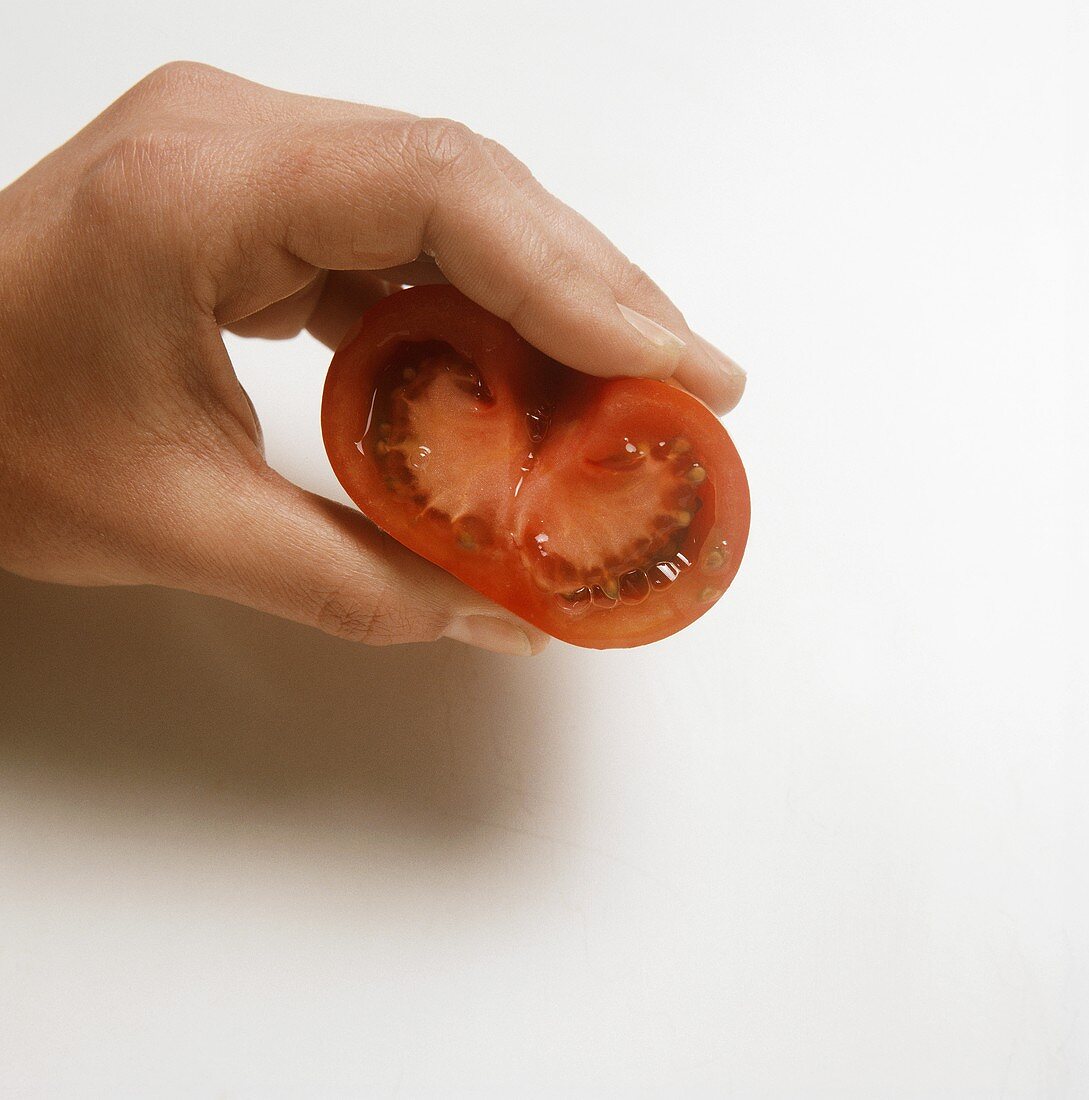 Removing the seeds from a halved tomato