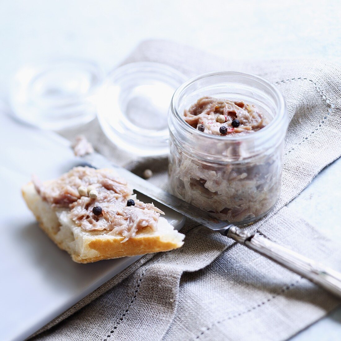 Duck rilettes in a jar and spread on a slice of baguette