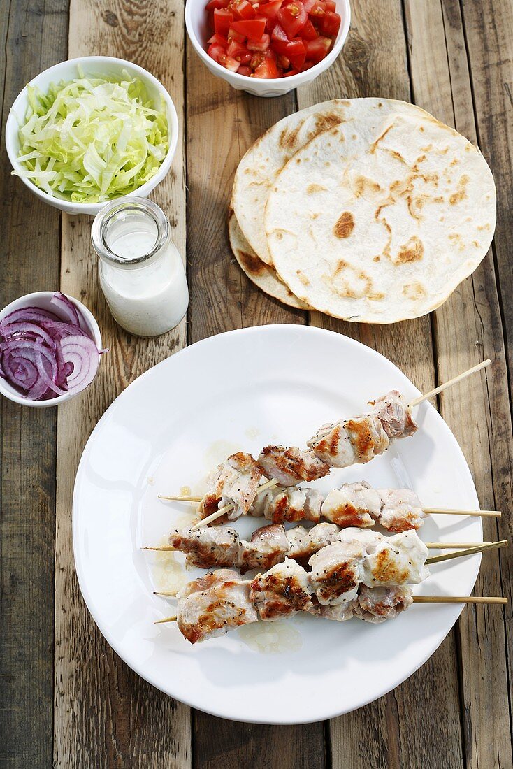 Chicken souvlaki, flat bread, yogurt and salad ingredients