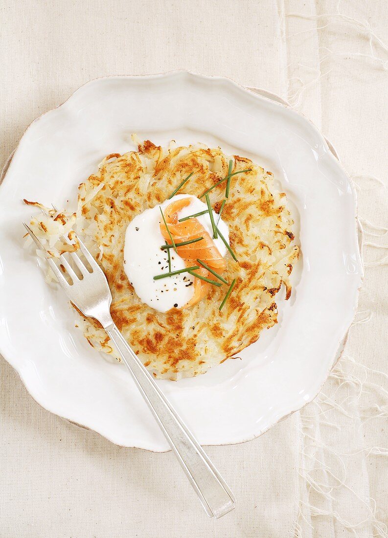 Rösti (fried Swiss potato cake) with sour cream and smoked salmon