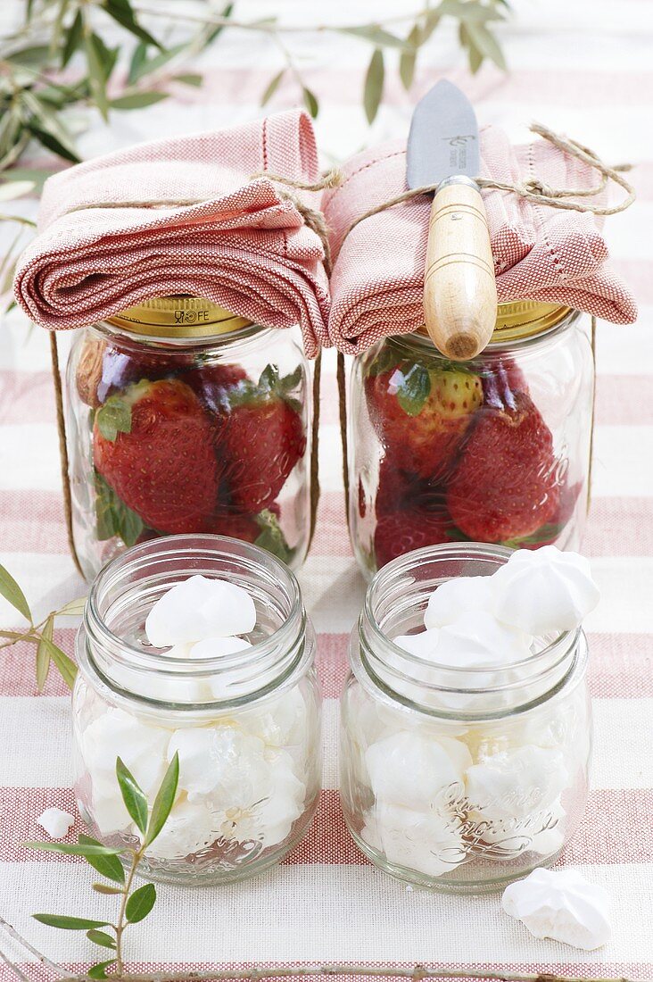 Baiserplätzchen und Erdbeeren auf Gartentisch