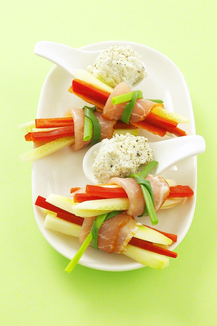 Cucumber and pepper sticks with raw ham and a cheesey dip