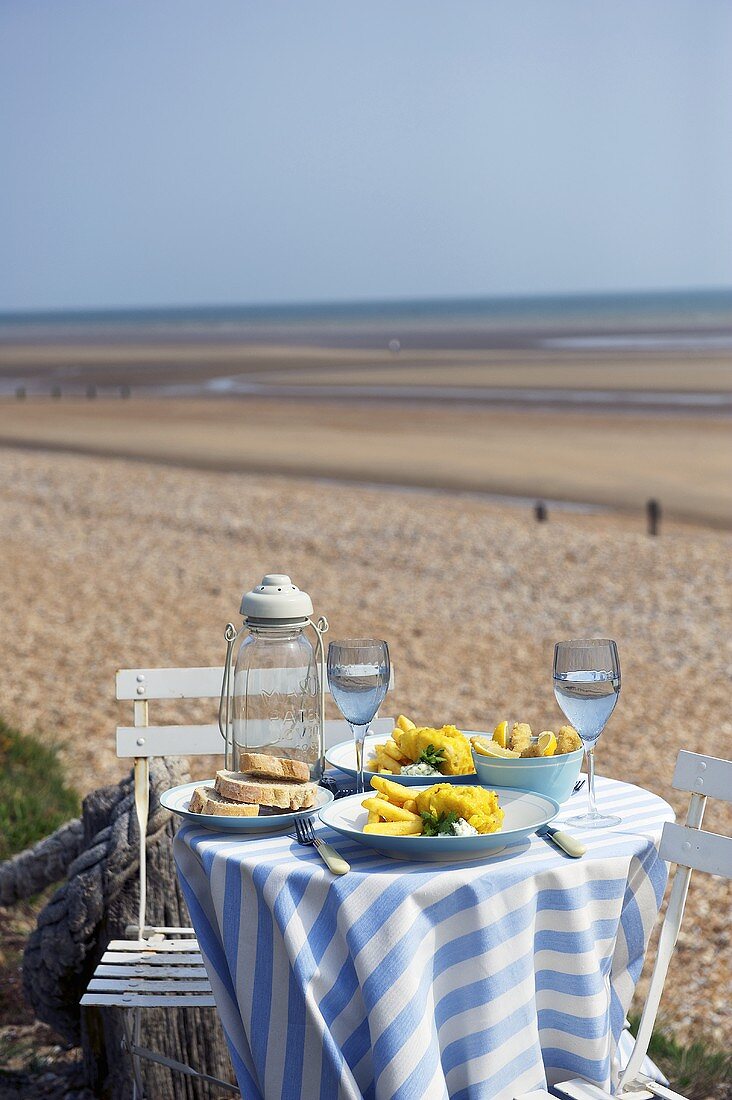 Fish and Chips auf Tisch am Strand