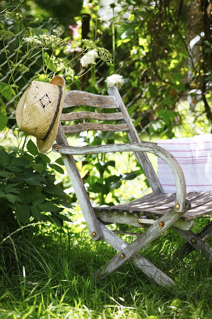 A straw hat on a garden chair