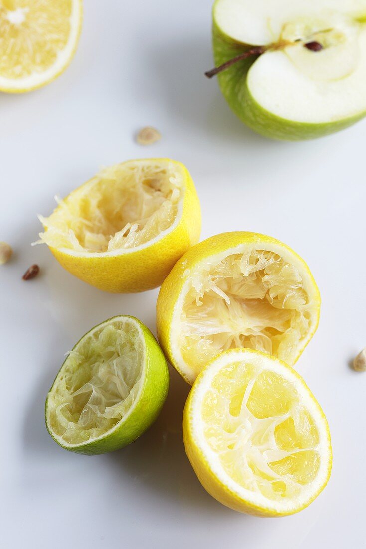 Ausgepresste Zitronen und Limette, halber Apfel